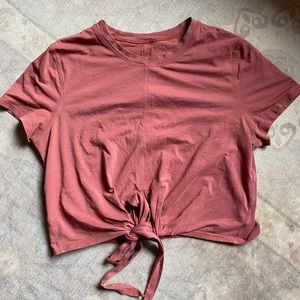 Lululemon. Burnt red color, great quality. Can tie the strings in front or back
